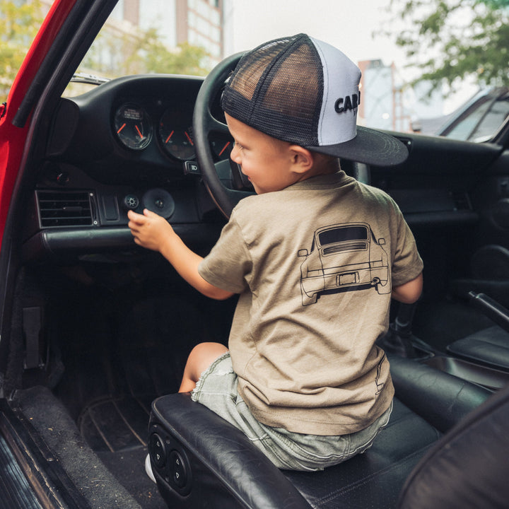 Little boy inside a Porsche 911 wearing a 964 t-shirt in Olive - Gearhead Kids 