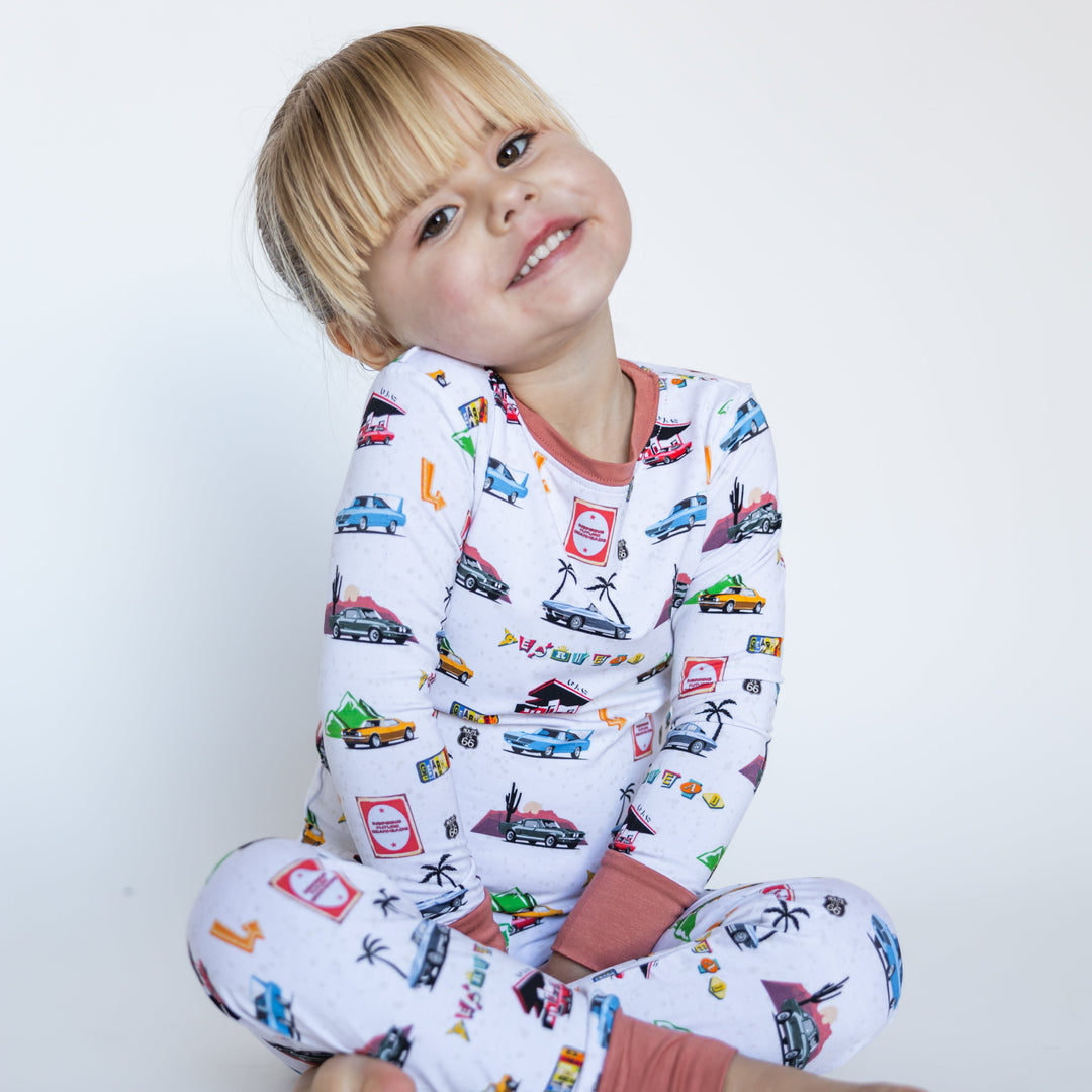 Girl wearing American muscle car pajamas with vintage Camaro Z28 and Challenger - Gearhead Kids