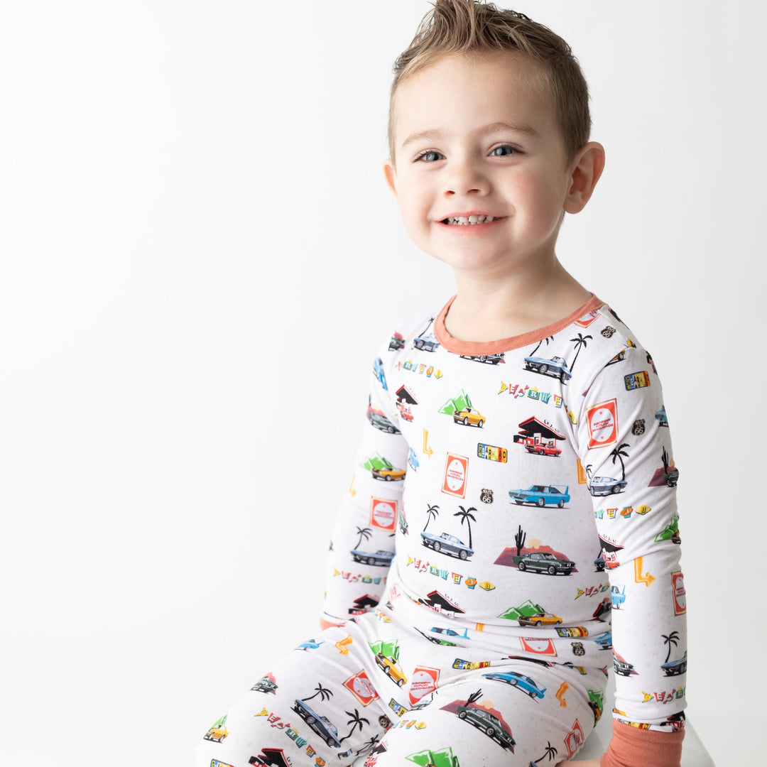 Toddler wearing American muscle car pajamas with vintage Camaro Z28 and Challenger silhouettes - Gearhead Kids