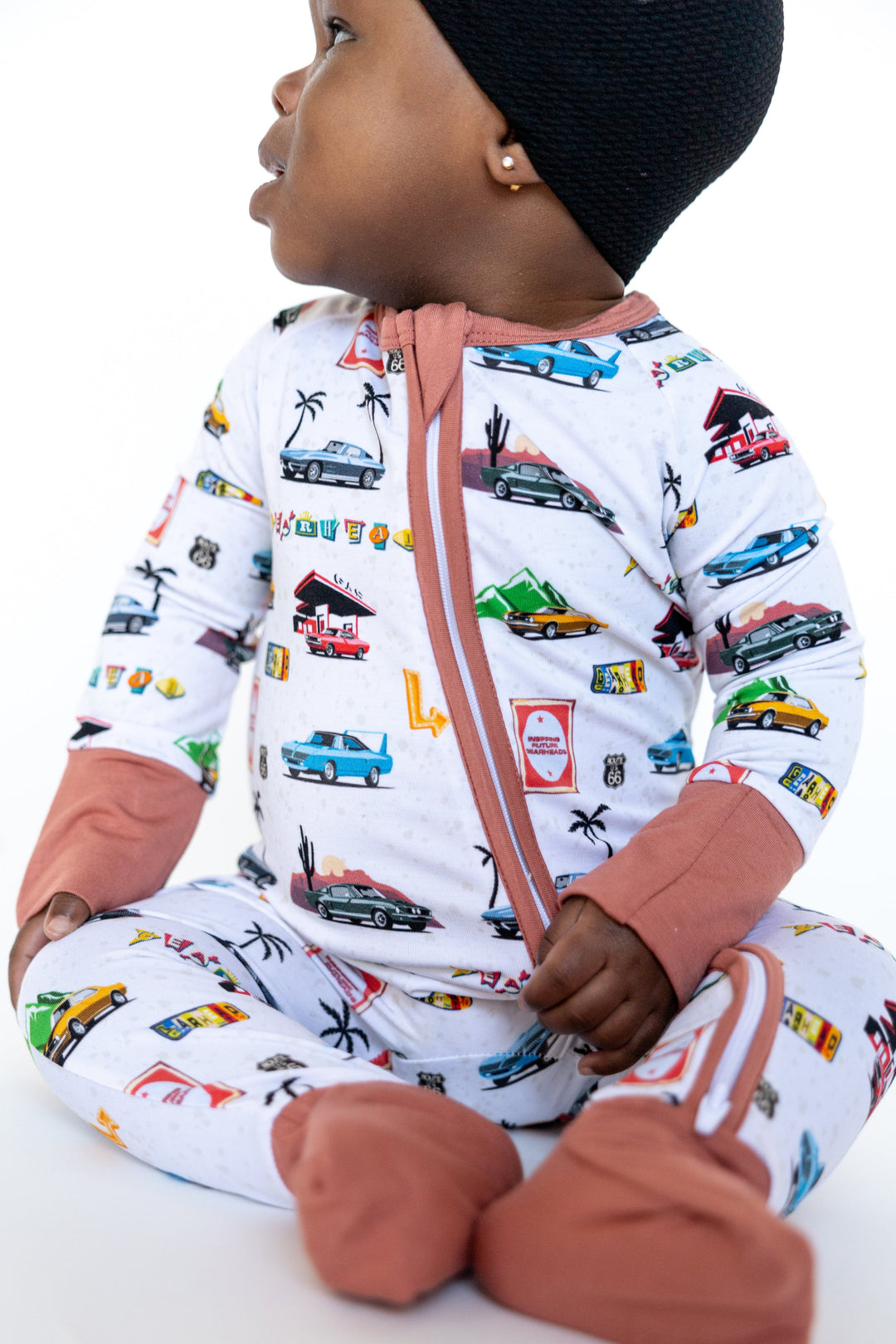 baby wearing American Road Trip baby zipper pajamas with Plymouth Superbird and Mustang Fastback print - Gearhead Kids