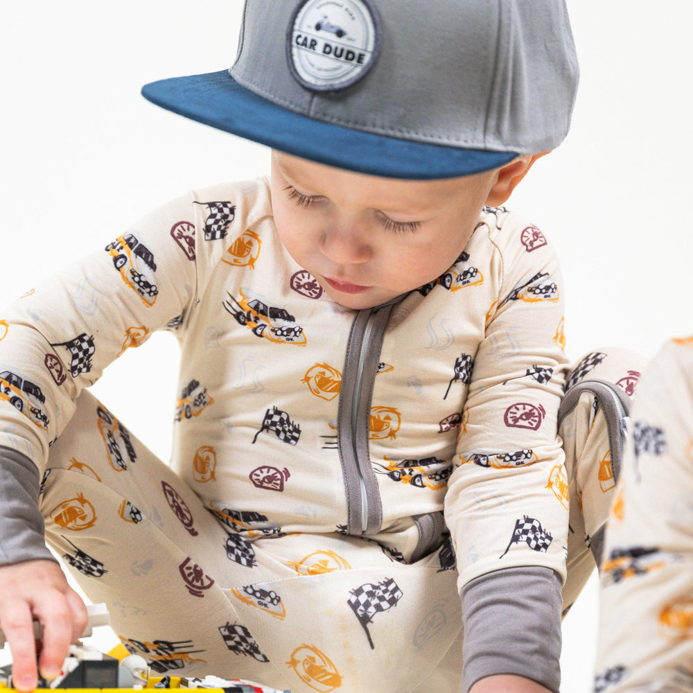 Baby in Rally Legend zipper pajamas featuring Audi Quattro S1 Group B rally car print in white and yellow livery - Gearhead Kids
