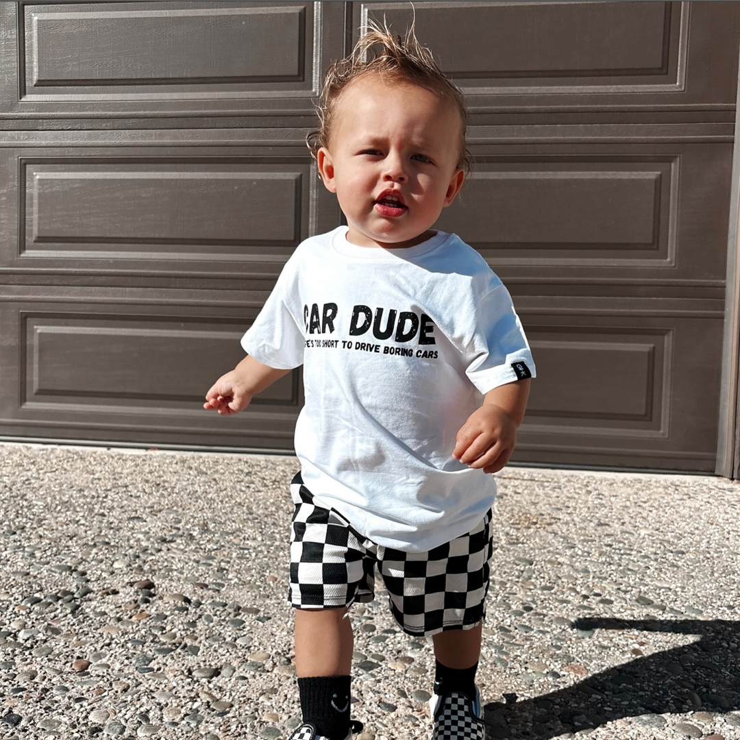 toddler wearing a white t-shirt with black text "CAR DUDE"  "Life's too short to drive boring cars" by Gearhead Kids
