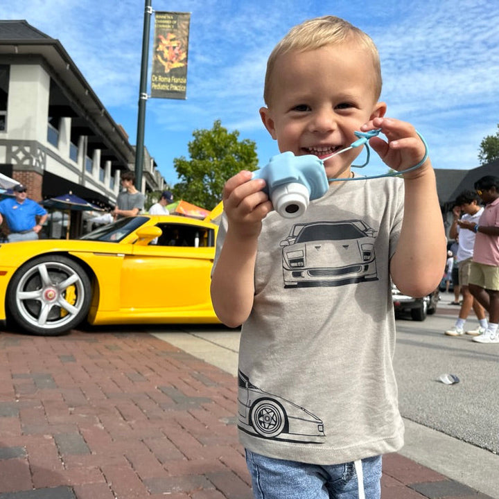 Young car enthusiast wearing a Ferrari F40 triple-profile graphic tee at a car show - Gearhead Kids