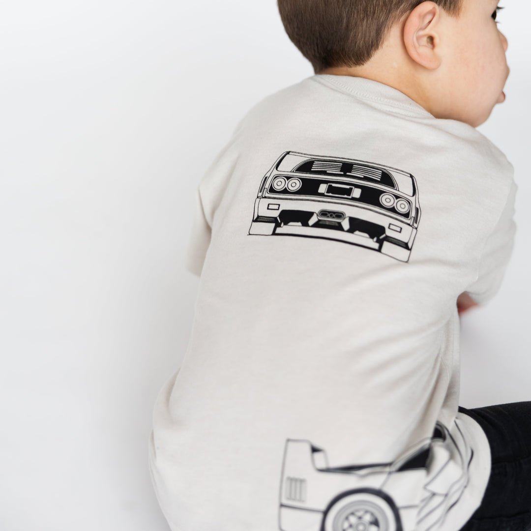 Toddler boy wearing a minimalist Ferrari F40 blueprint style t-shirt for kids in dust  - Gearhead Kids