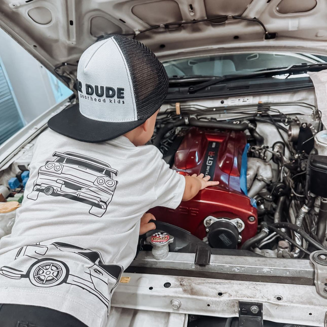 Toddler wearing nissan gt-r tee peeking at the engine of a GT-R car - Gearhead Kids 