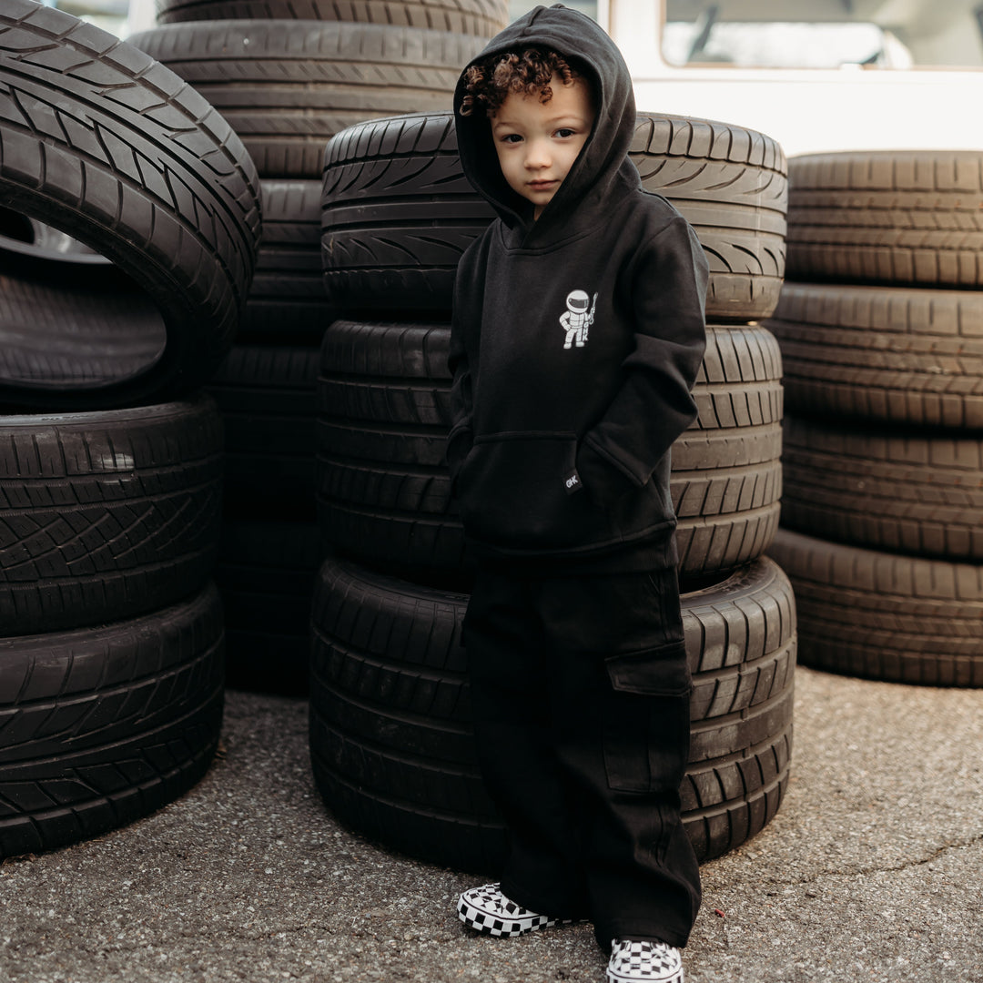 Little boy wearing a black hoodie with a Stig Figure logo on the front.  Gearhead Kids - Clothing for Automotive Enthusiasts