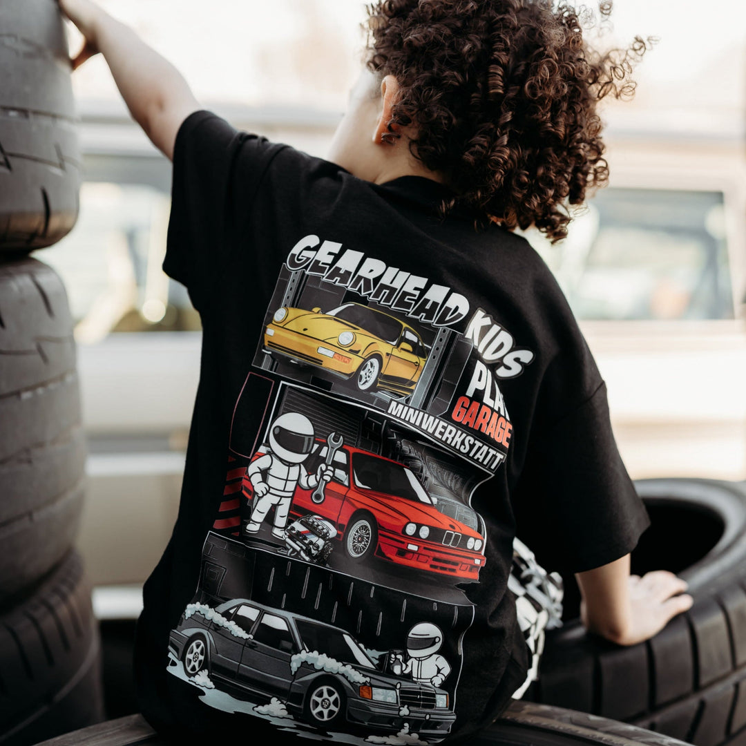 Toddler boy wearing a Gerhead Kids - Play Garage t-shirt featuring German Cars - BMW M3, Mercedes 190E Evo II, and Porsche 911, Air-cooled 964.