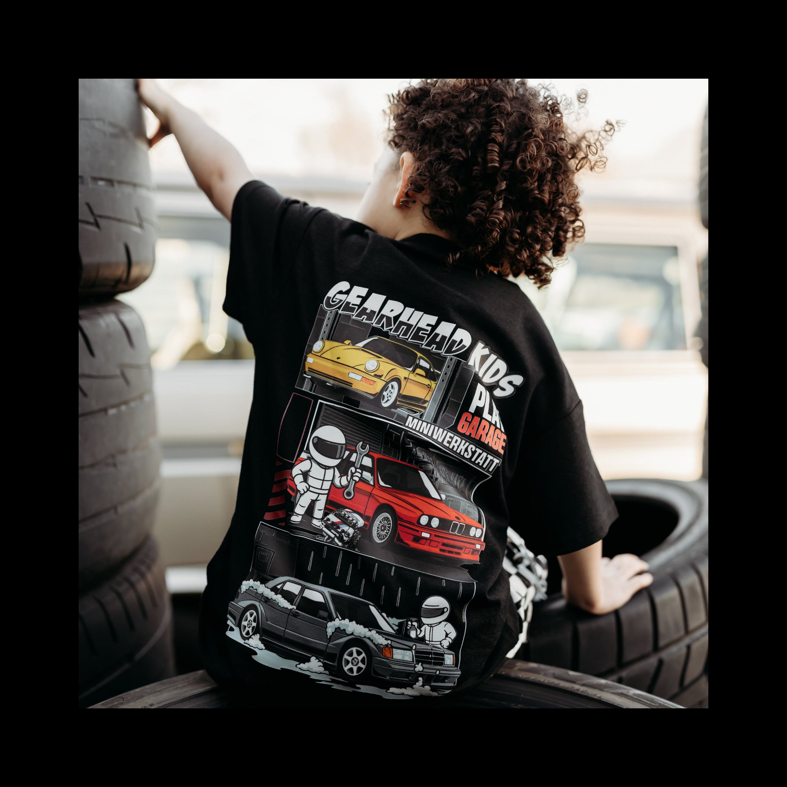 Toddler boy wearing a Gerhead Kids - Play Garage t-shirt featuring German Cars - BMW M3, Mercedes 190E Evo II, and Porsche 911, Air-cooled 964.