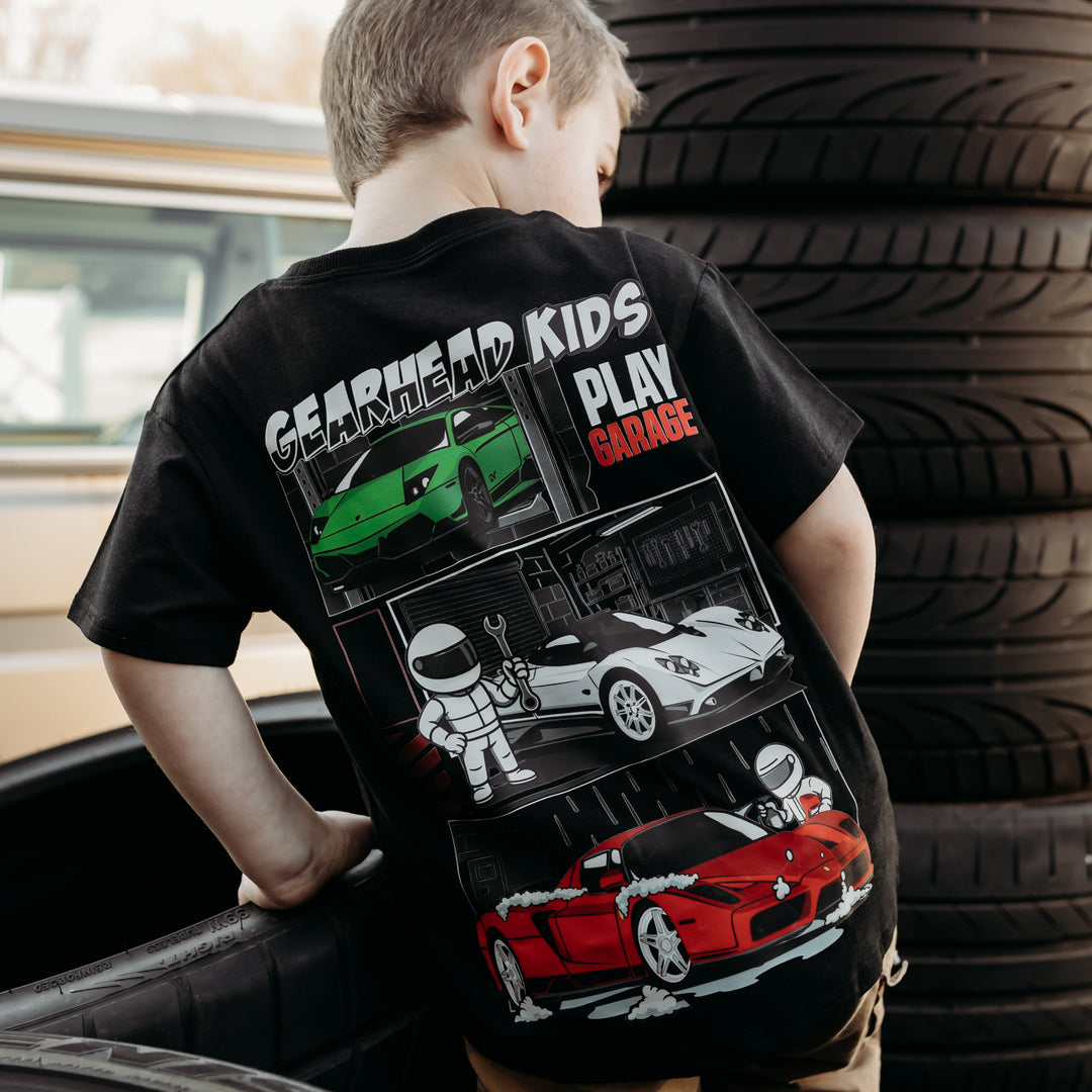 Toddler boy wearing a Gearhad Kids Play Garage black T-Shirt for Kids - Featuring Italian Exotic Cars - Ferrari Enzo, Lamborghini Murciélago, Pagani Zonda.  Car Apparel for Kids.