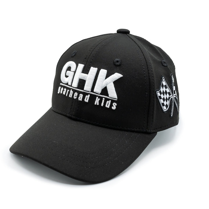 A black structured baseball cap with 'GHK Gearhead Kids' printed in white on the front and black and white checkered flags on the side