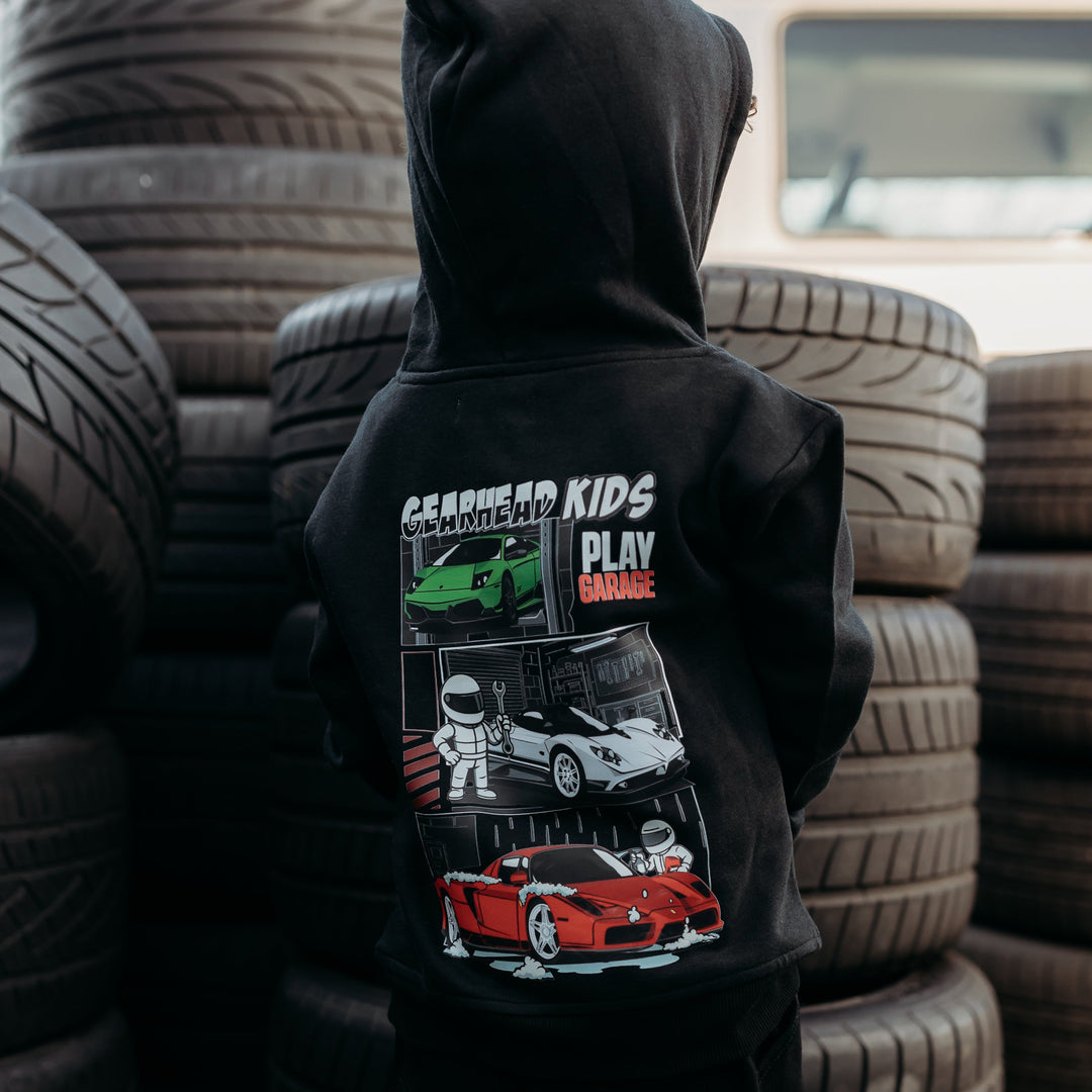 Little boy wearing a black Play Garage Hoodie with Green Lamborghini Murcielago, White Pagani Zonda and Red Ferrari Enzo supercars.  Gearhead Kids - Automotive Apparel for Kids
