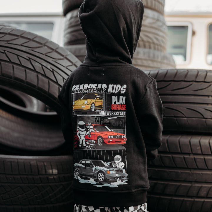 Little boy wearing a Play Garage hoodie with yellow Porsche 964, Red BMW E30 M3 and Gray Mercedes 190 Evo II.  Gearhead Kids - Car Clothes for Kids