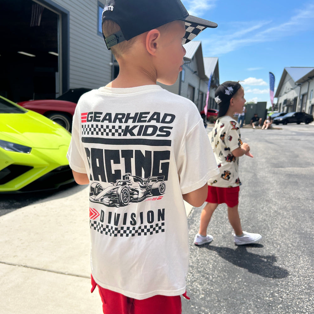 Little boy wearing a white t-shirt with a large back graphic of a detailed open wheel race car and bold RACING DIVISION text.  | Gearhead Kids 