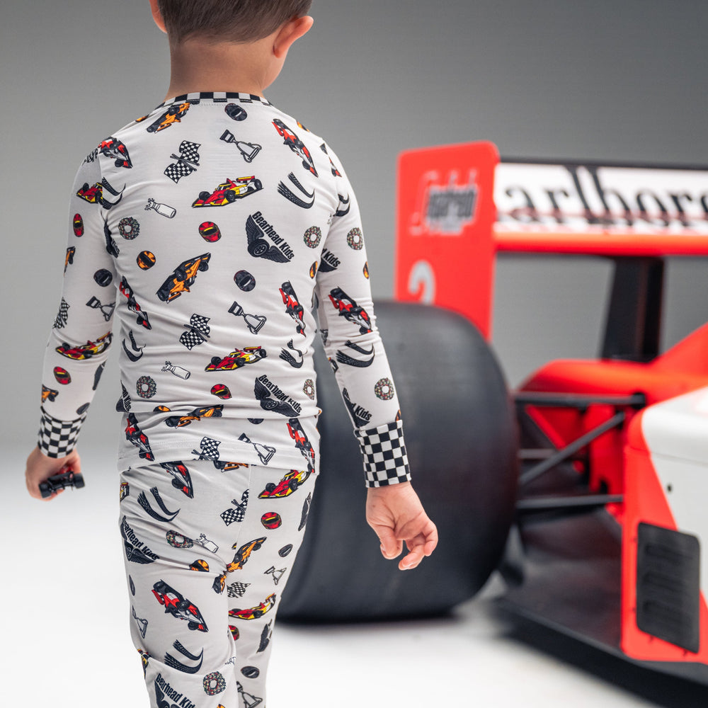 Little boy wearing Indy Car Racing pajamas next to an Indy Car race car  | Gearhead Kids