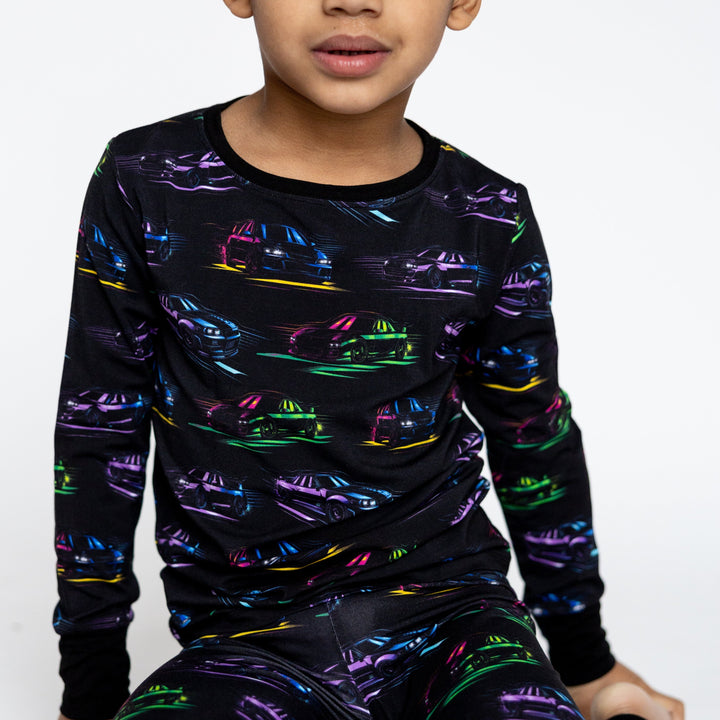 Closeup of JDM car pajamas featuring Nissan R34 GTR and Toyota Supra MK4 silhouettes in bright neon colors - Gearhead Kids 