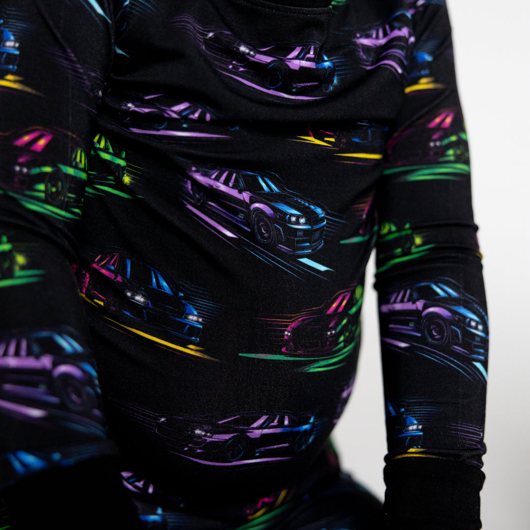 Closeup of JDM car kids pajamas featuring Nissan R34  in bright neon colors
