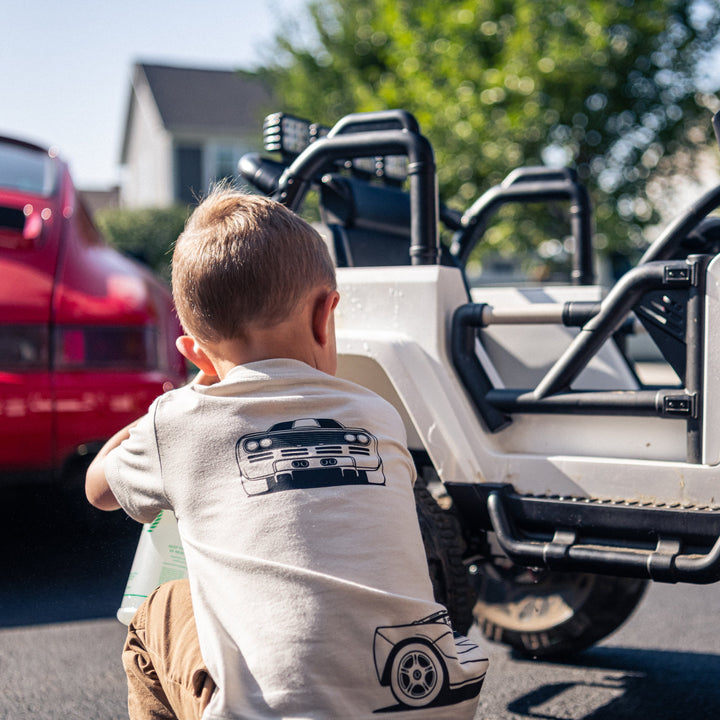 Little boy wearing a McLaren F1 Tee while washing his car - Gearhead Kids