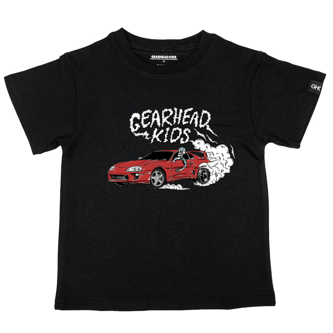 Kids black t-shirt featuring a skeleton driving a red MK4 Toyota Supra doing a burnout with Gearhead Kids smoke graphic