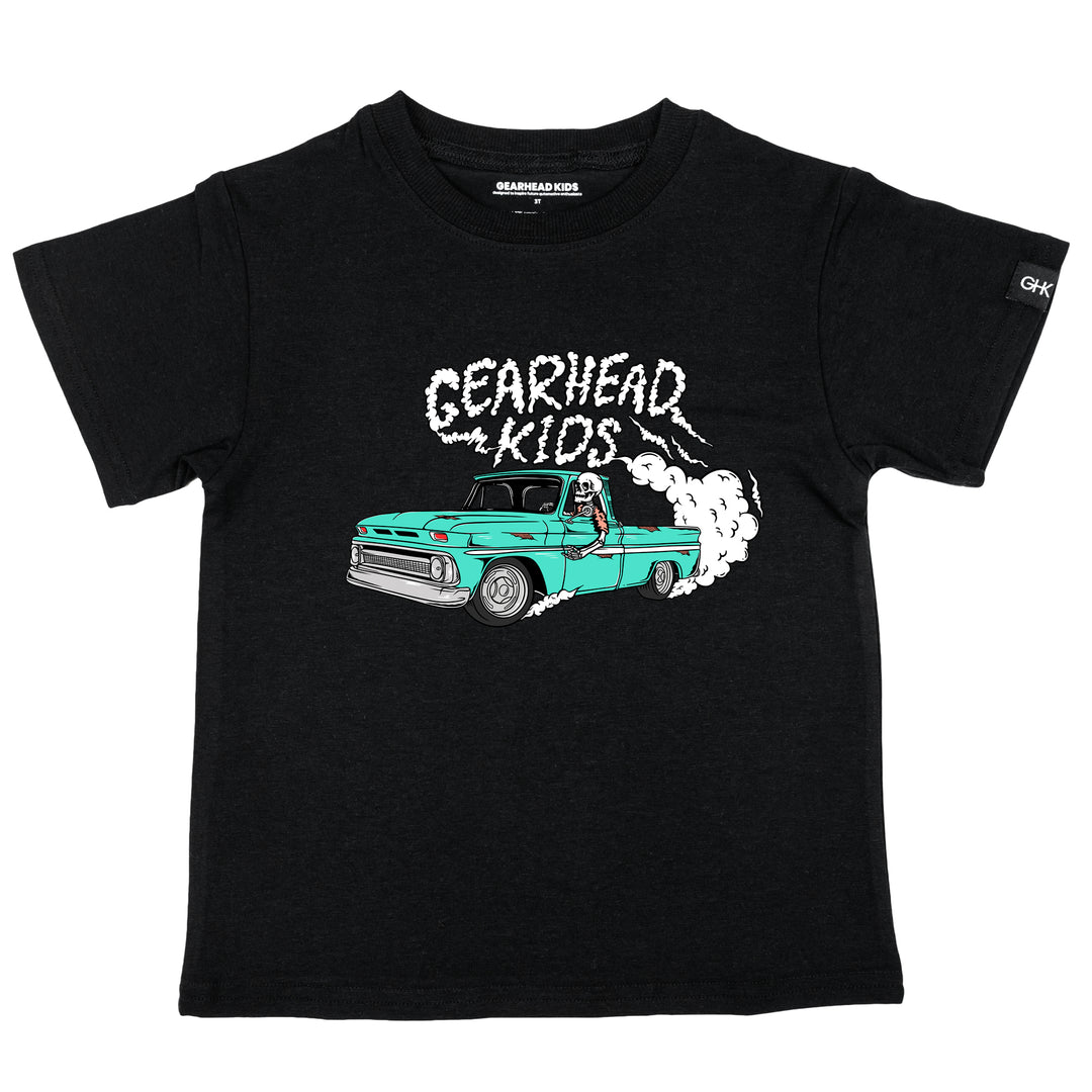 Kids black t-shirt featuring a skeleton driving a turquoise classic Chevy C10 pickup truck doing a burnout with Gearhead Kids smoke graphic